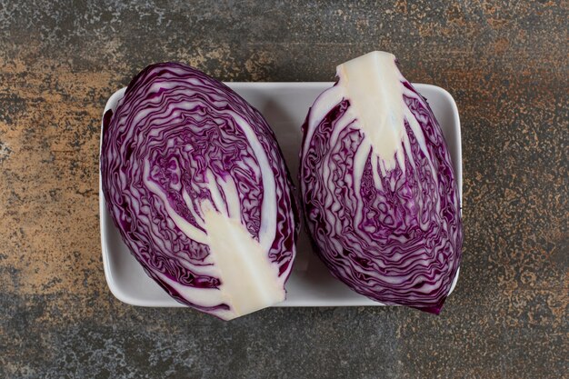 Two piece of red cabbage in the bowl on the marble surface