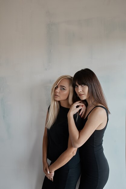 Two pretty woman in a black dress indoor