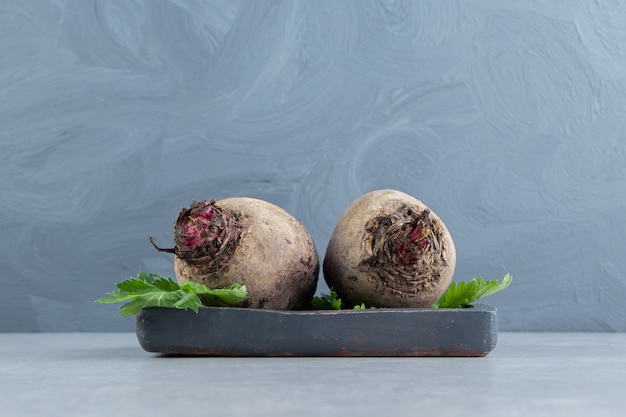 Two radishes in the tray , on the marble background.