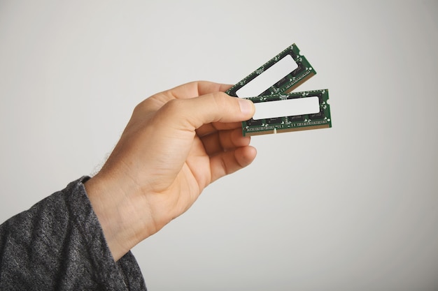 Two RAM chips in a man's hand isolated on white