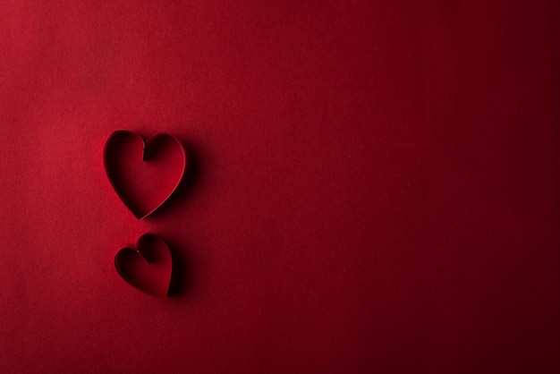 Two red hearts against red background