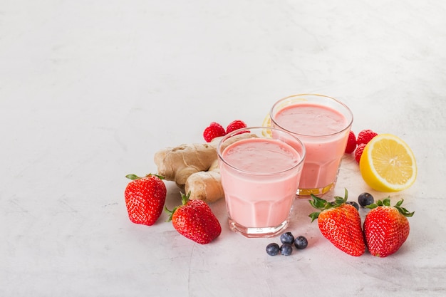 Two red smoothies with strawberries, ginger and lemon