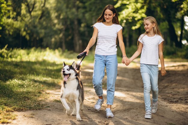 Two sisters with their dog in park