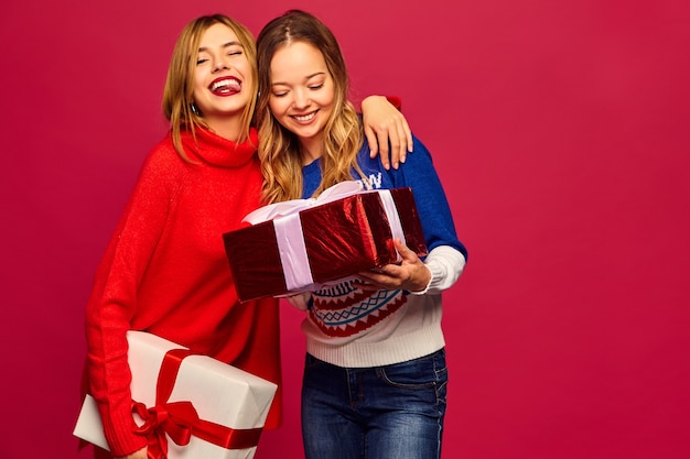 Free photo two smiling beautiful women in stylish sweaters with big gift boxes