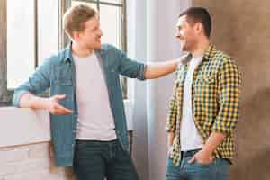 Free photo two smiling young men talking to each other