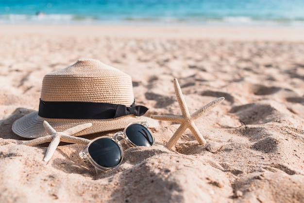 Two starfishes with hat on sand