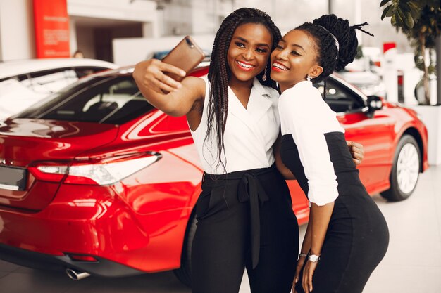 Two stylish black women in a car salon