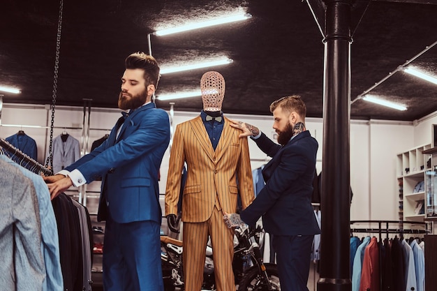 Free Photo two stylish shop assistants elegantly dressed working in a menswear store.