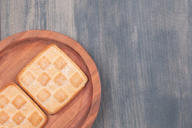 Two sweet biscuits on wooden plate