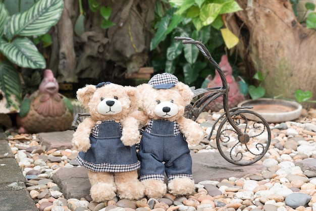 two teddy bears on garden background