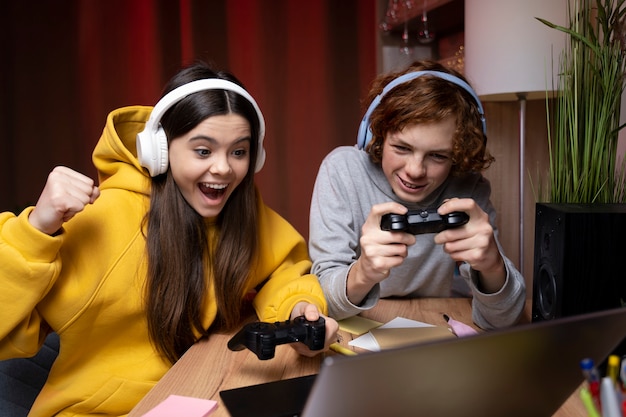 Free photo two teenage friends playing video games together at home