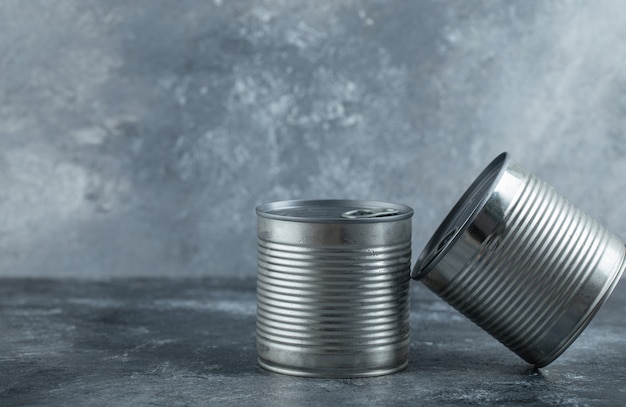 Free photo two tin cans placed on marble.