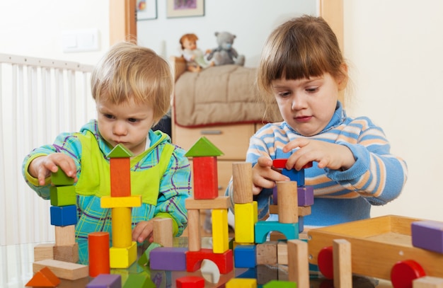 Two  tranquil children playing with wooden toys