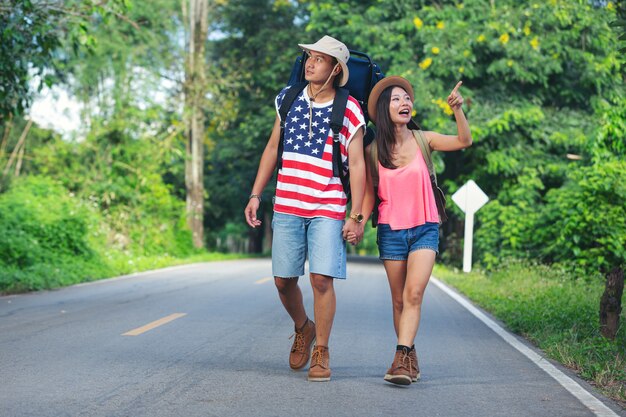 Two travelers walking on country side street