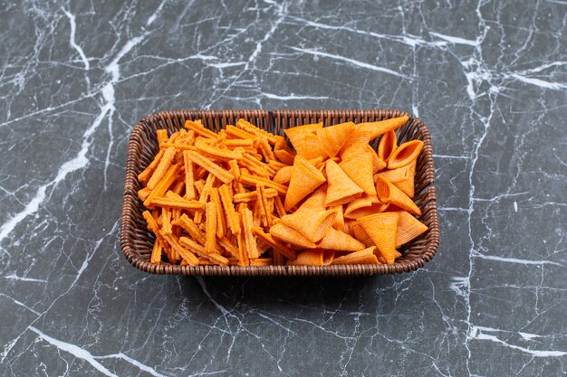 Two types of crunchy chips in wooden basket.