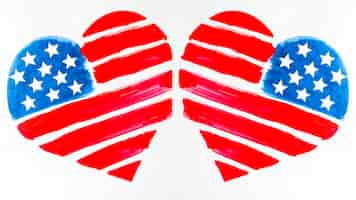 Free photo two usa flag painted heart shapes on white background