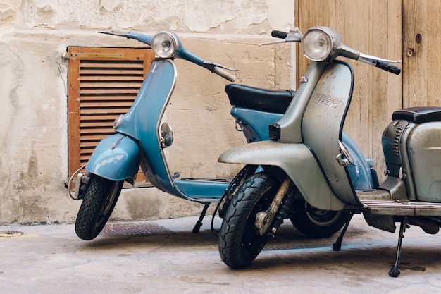 Free photo two vintage scooters parked on the street