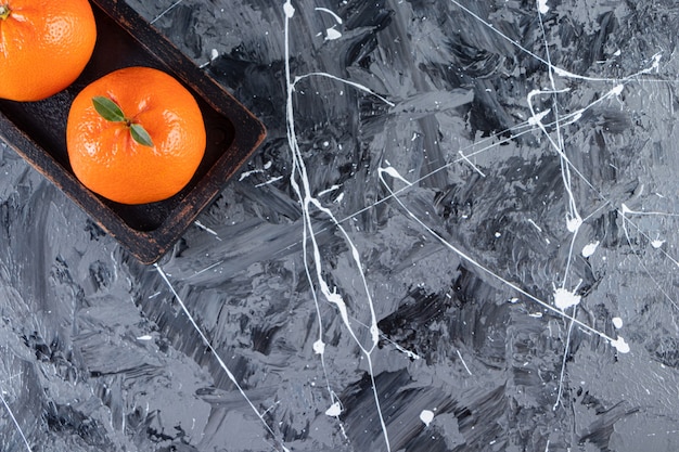 Free Photo two whole fresh orange fruit on a wooden board.