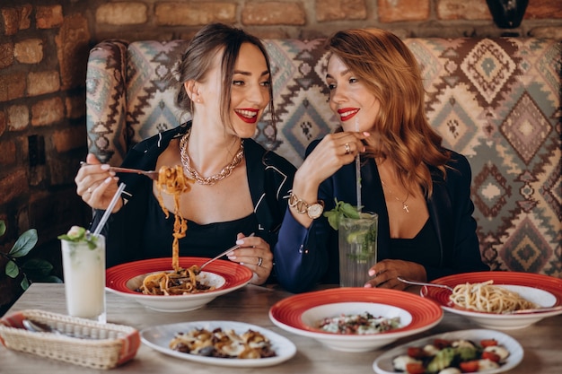 Two women eating pasta in an italian restaurant