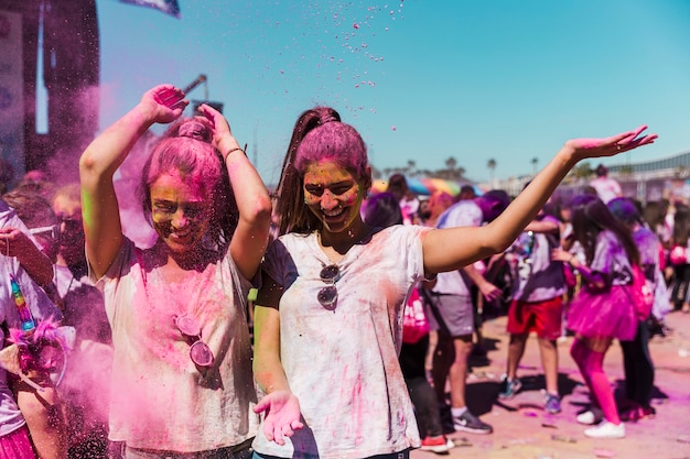 Two women enjoying and playing with holi powder