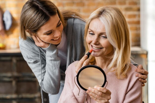 Two women getting their make-up on at home