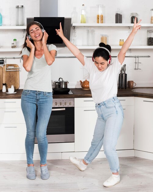 Two women listening and dancing to music on headphones