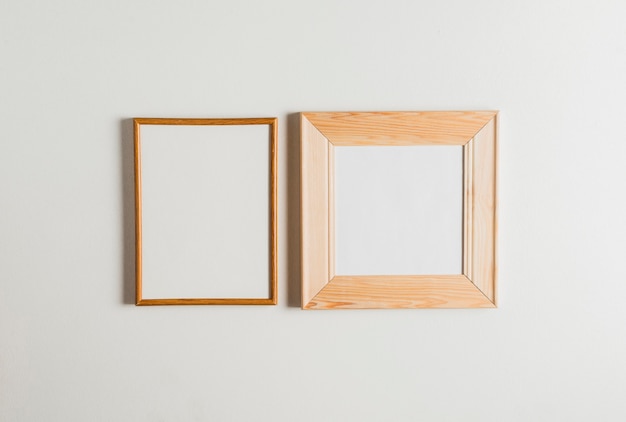 Free photo two wooden frames hanging on white wall