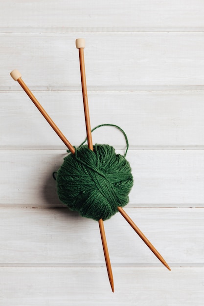 Free photo two wooden needles in ball of wool