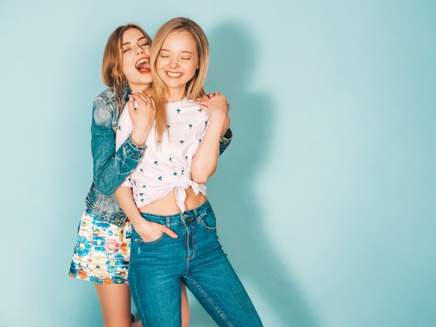 Free photo two young beautiful smiling blond hipster girls in trendy summer colorful  clothes.