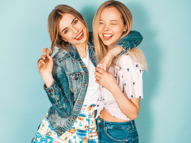 Free photo two young beautiful smiling blond hipster girls in trendy summer colorful  clothes.