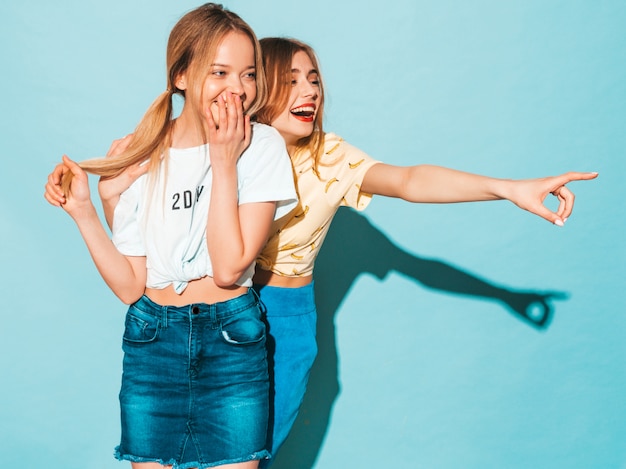 Free photo two young beautiful smiling blond hipster girls in trendy summer colorful t-shirt clothes.