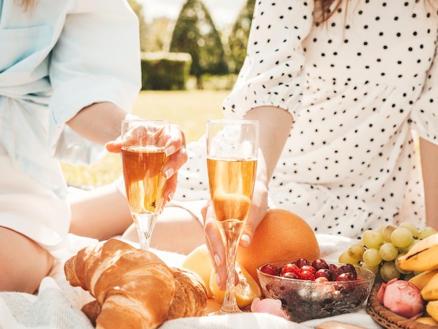 Free Photo two young beautiful smiling hipster female in summer sundress and hats.carefree women making picnic outside.