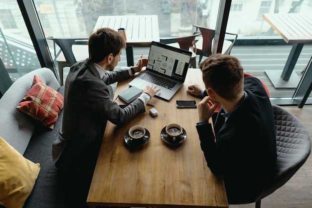 Two young businessman having a successful meeting at restaurant.