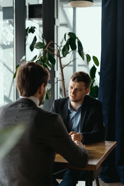 Free photo two young businessmen discussing something