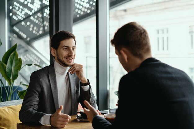 Two young businessmen discussing something