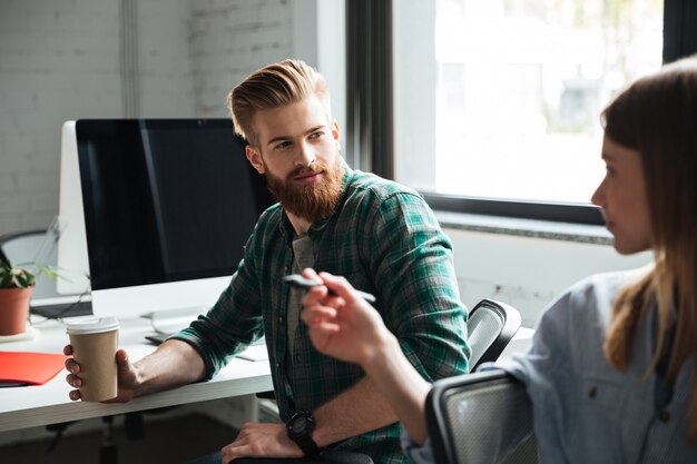 Two young concentrated colleagues work in office