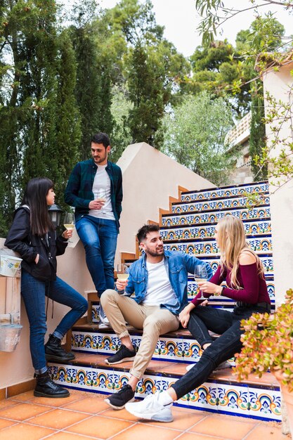 Two young couples enjoying drink on staircase