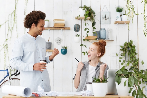 Two young coworkers feelings happy and excited, glad with successful presentation