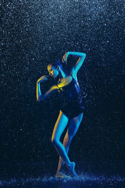 Two young female ballet dancers under water drops