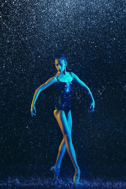 Two young female ballet dancers under water drops