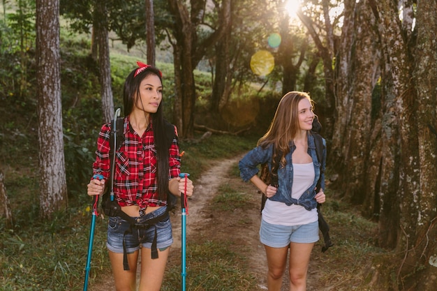 Free photo two young female friends hiking in forest