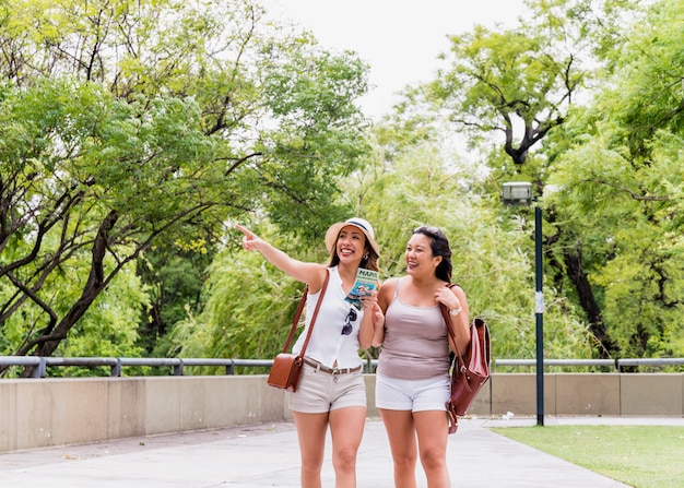 Two young female tourist walking in the park looking away