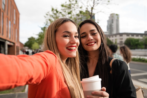 Two young friends taking a selfie outdoors.