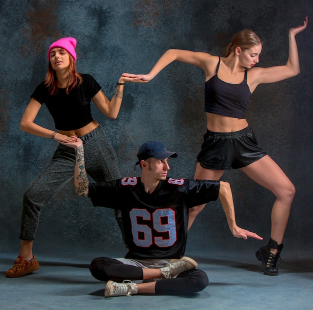 Free photo the two young girls and boy dancing hip hop at the blue