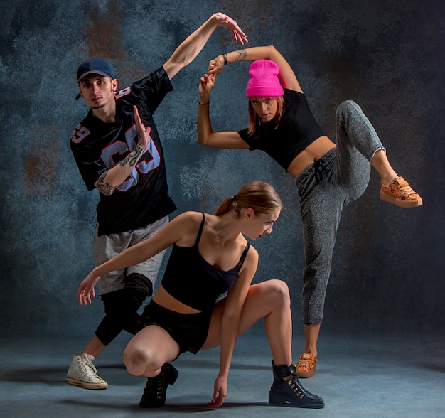 two young girsl and boy dancing hip hop in