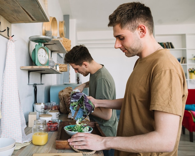 Free Photo two young man making morning breakfast in kitchen