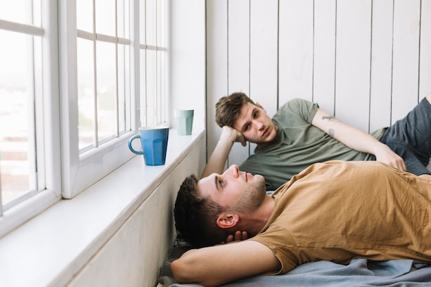 Free photo two young man resting near window