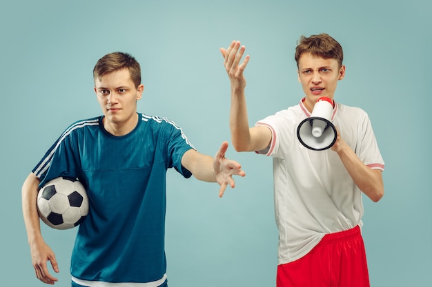 Two young men standing in sportwear isolated on blue