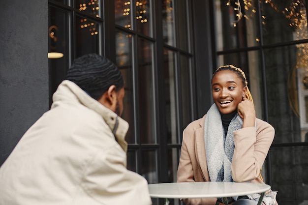 Two young people sitting outside. African couple enjoying the time spending with each other.