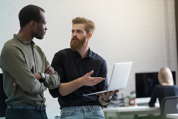 Two young smart business men discussing new project